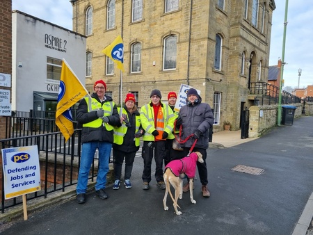 Image shows 4 PCS members with flags, a postal worker and a greyhound